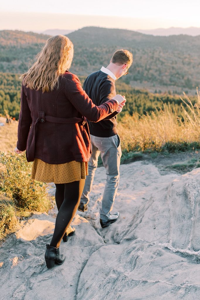 engaged couple hiking in asheville mountains yellow dress holding hands
