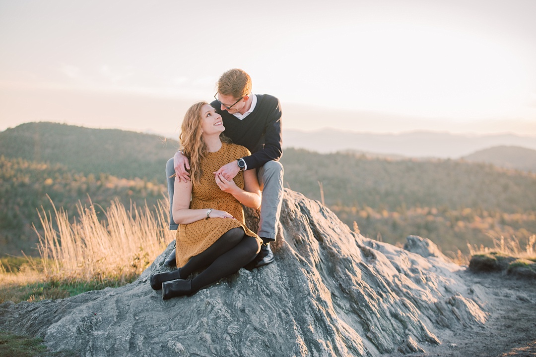 Engaged couple sitting on black balsam knob mountaintop engagement asheville nc engagement