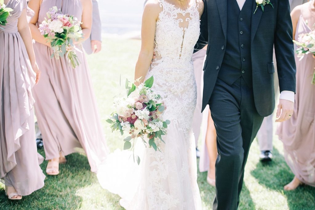 bride and groom walking at cliffs at glassy chapel brunch wedding with wedding party bridesmaids groomsmen purple bridal bouquet film photography