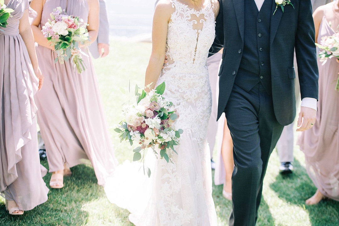 bride and groom walking at cliffs at glassy chapel brunch wedding with wedding party bridesmaids groomsmen purple bridal bouquet film photography