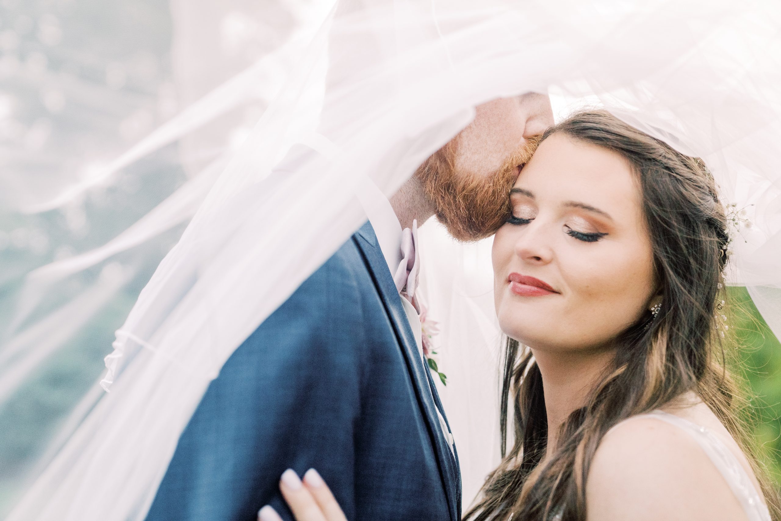 Bride and groom kissing with eyes closed, underneath veil, viewpoint at buckhorn creek, greenville sc wedding